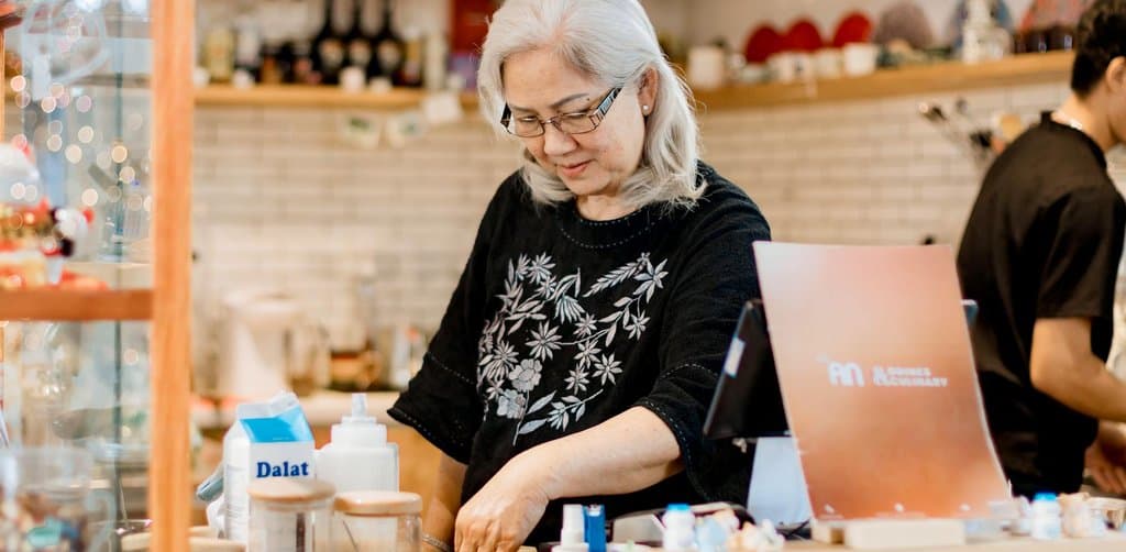 Franchise unit operator working behind the counter in a food and beverage location, representing the unit-level cash flow that drives acquisition financing