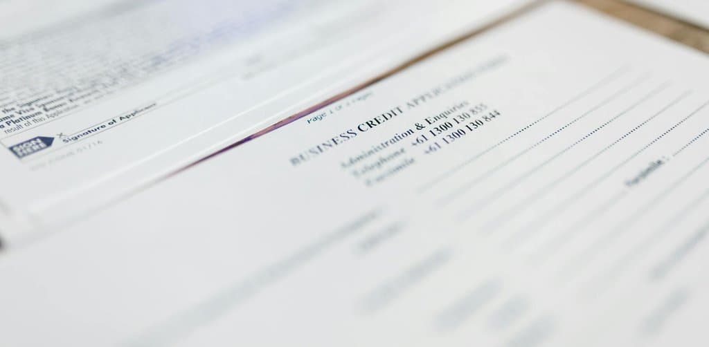 Business credit application document close-up showing the paperwork phase of acquisition financing for franchises