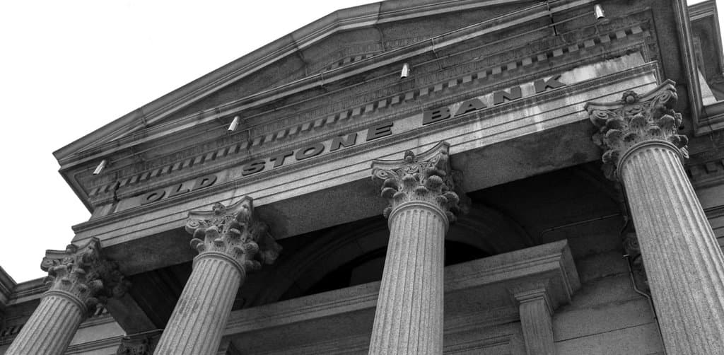 Old Stone Bank facade with Corinthian columns, representing the institutional lenders who most often demand a blanket lien on all business assets