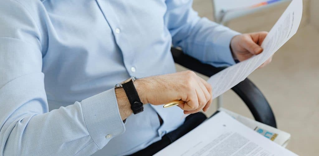 Hands reviewing business note paperwork to evaluate payment performance