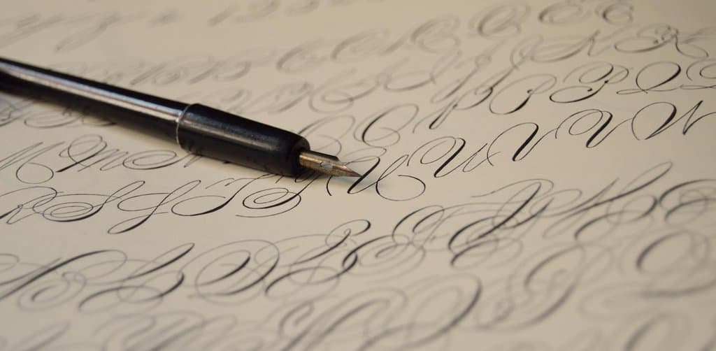 Dip pen resting on ornate handwritten script, illustrating the signed security agreement that anchors the difference between UCC filing and lien