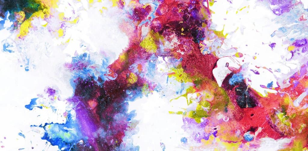 An abstract watercolor splatter painting in vivid magenta crimson cobalt blue golden yellow and indigo violet pigments dripping splashing and blending freely across a stark white paper background creating organic irregular blooms of saturated color in the center of the frame with bright pinpoints of yellow drips scattered across the surrounding white space, the abstract flexibility metaphor for the multiple cash-out routes and timing options available within an employee stock ownership plan cash out election
