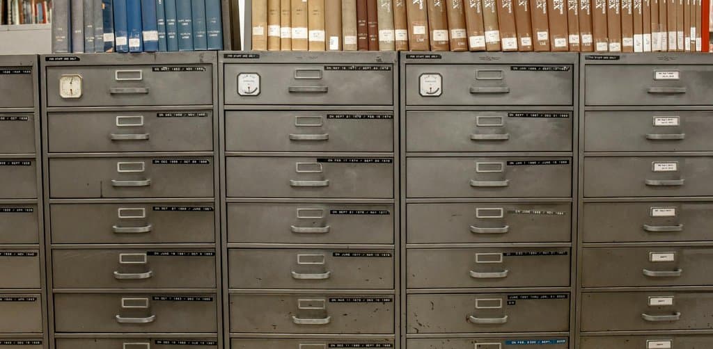 Old metal filing cabinets and index books in a records office, the destination for a business lien filing