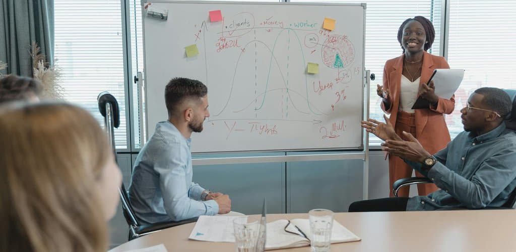 Diverse team mapping growth strategy on a whiteboard, the kind of operating discussion a minority investor should be participating in before writing a check
