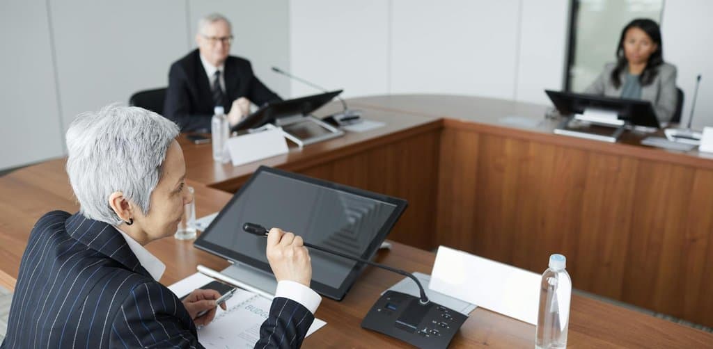 Boardroom executives reviewing mezzanine financing terms for a small business acquisition