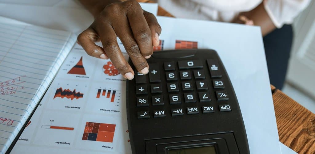 Hand calculating mezzanine financing returns and capital structure for a small business acquisition deal