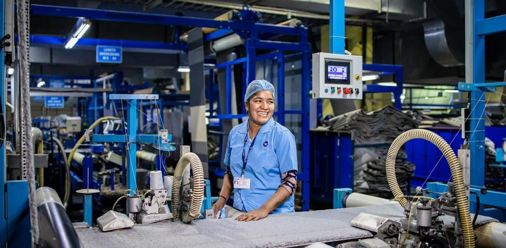 Factory operator working at textile machinery, the kind of equipment that frequently anchors the collateral package on a term business loan